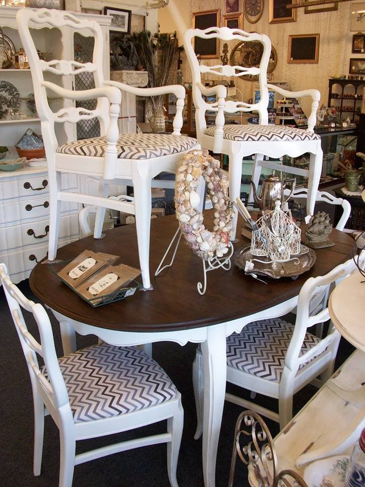 French provincial dining set with white-painted chairs in chevron fabric around a refinished dark wood table